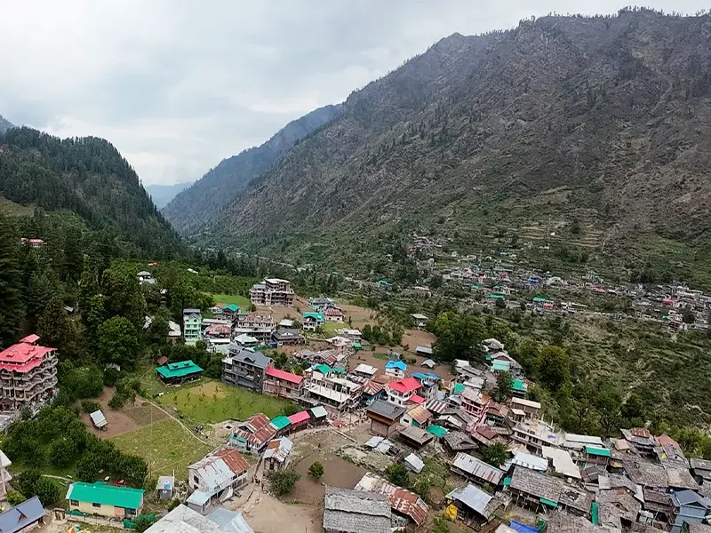 “Pulga Village Himachal surrounded by pine trees and wooden cottages”
